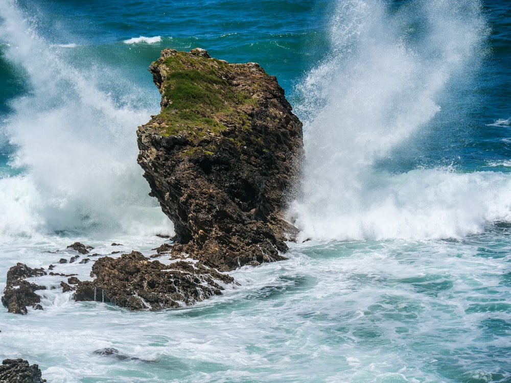 a large rock sticking out of the ocean