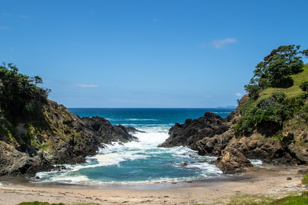 a sandy beach with waves crashing into the shore