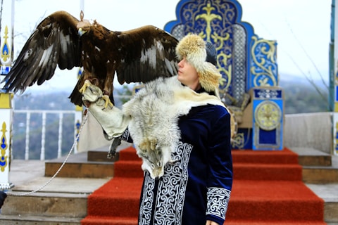 a woman with a large bird on her arm