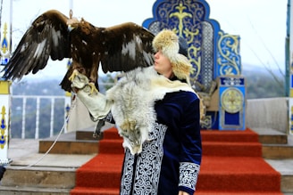 a woman with a large bird on her arm