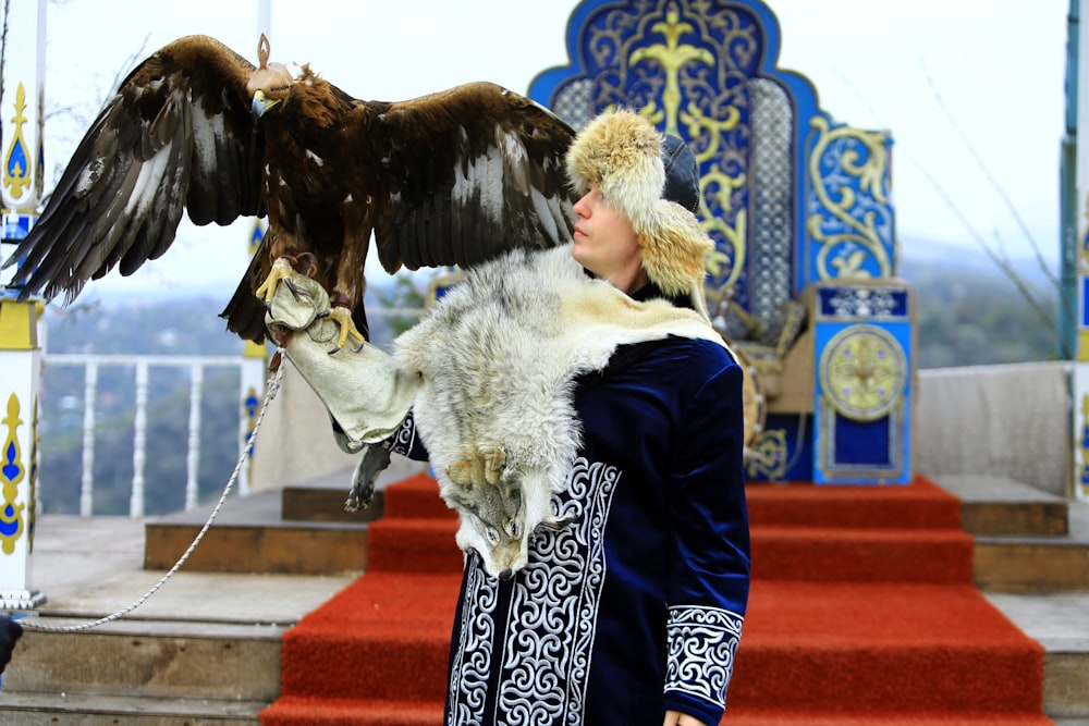 a woman with a large bird on her arm