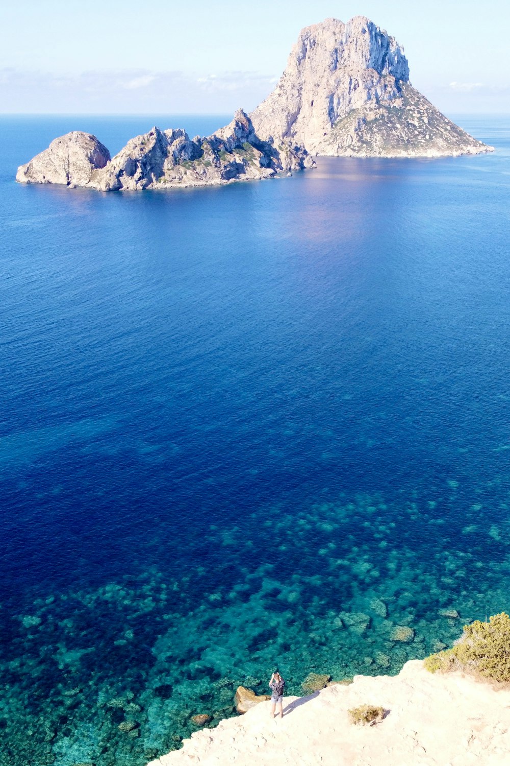 a person standing on a cliff overlooking a body of water