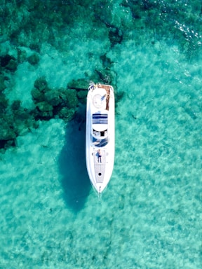 A professional marine surveyor inspecting a yacht deck under clear blue skies.