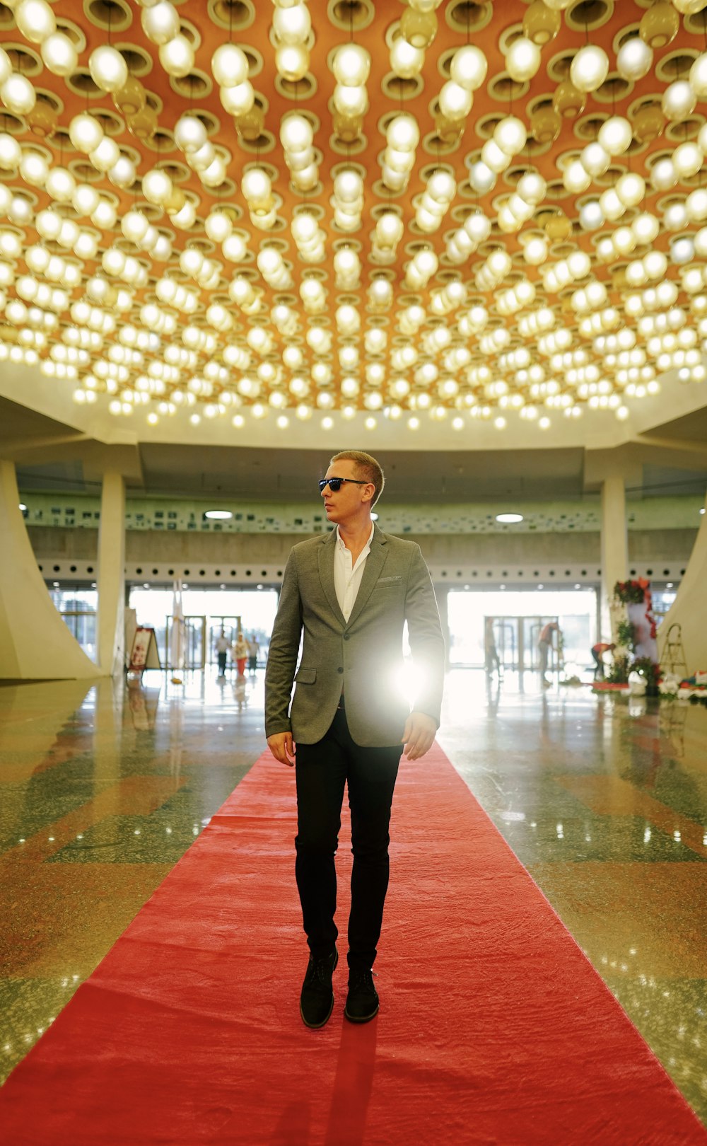 a man is walking down a red carpet