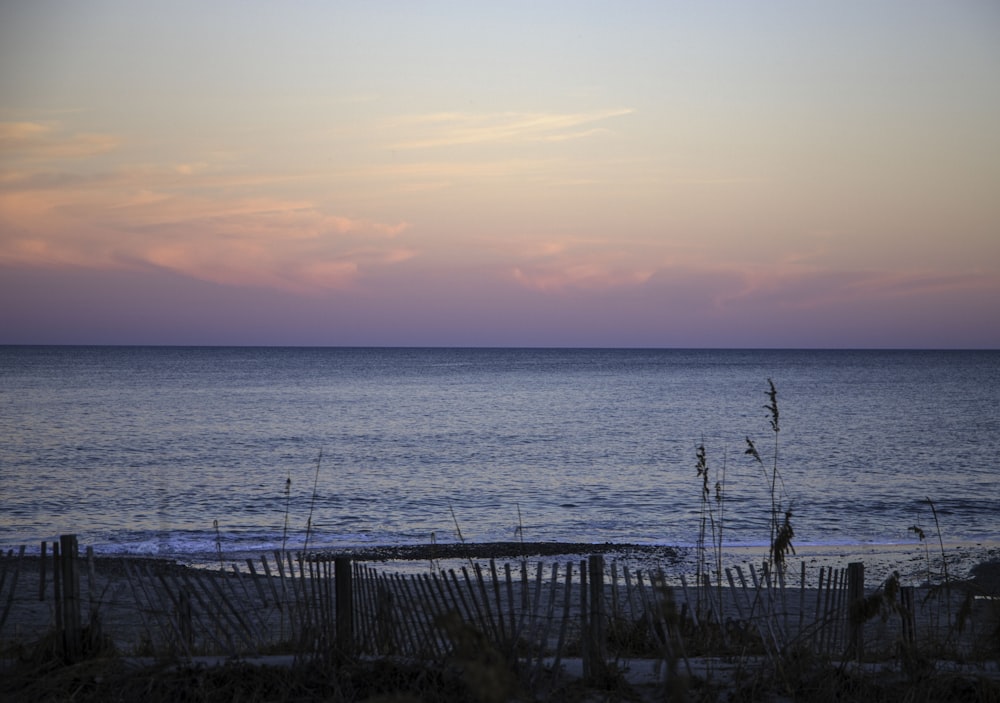 a view of the ocean at sunset from a beach