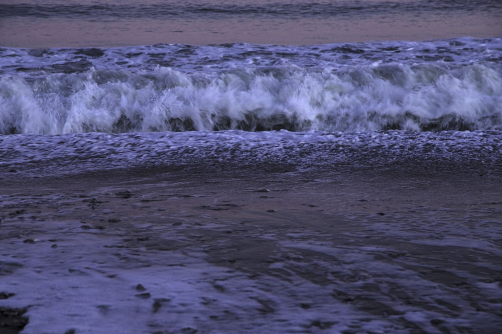 a person walking on the beach with a surfboard