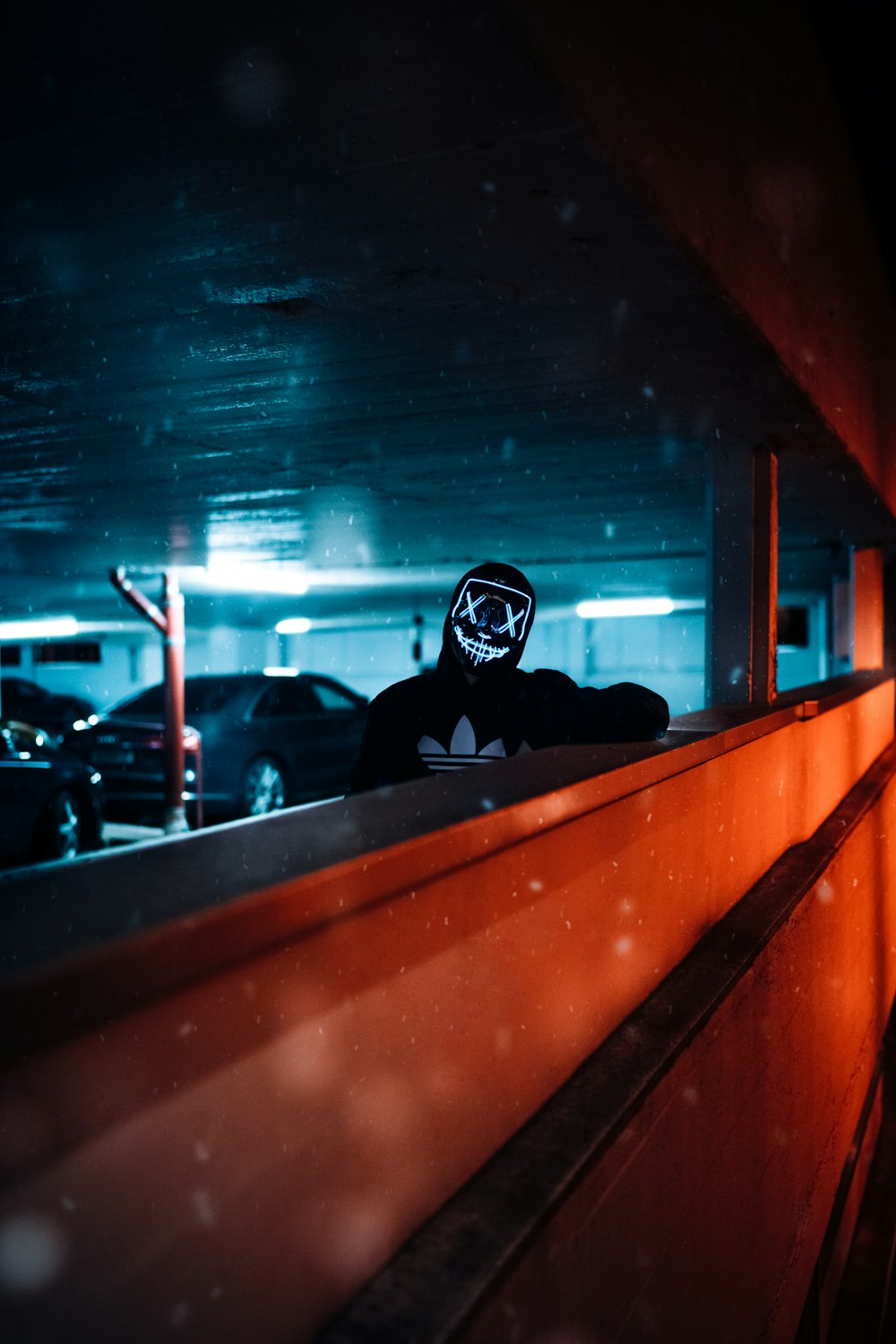 a person wearing a mask standing in a parking garage