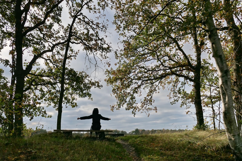 a person sitting on a bench in the woods