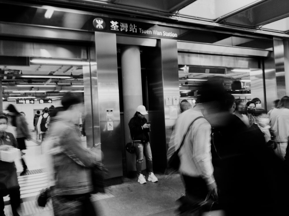 a black and white photo of people at a train station