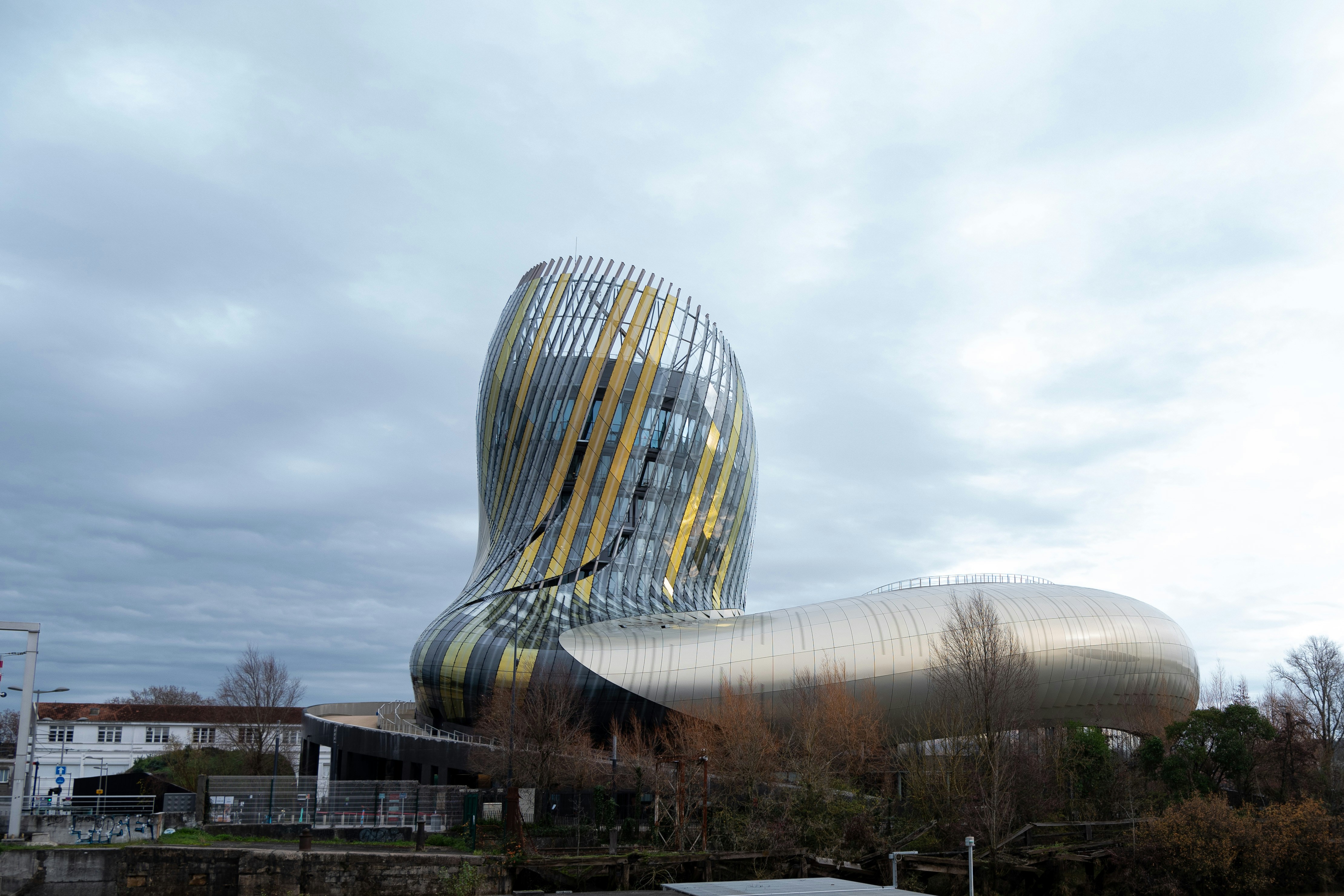 Un gran edificio con una estructura metálica curva junto a un cuerpo de agua