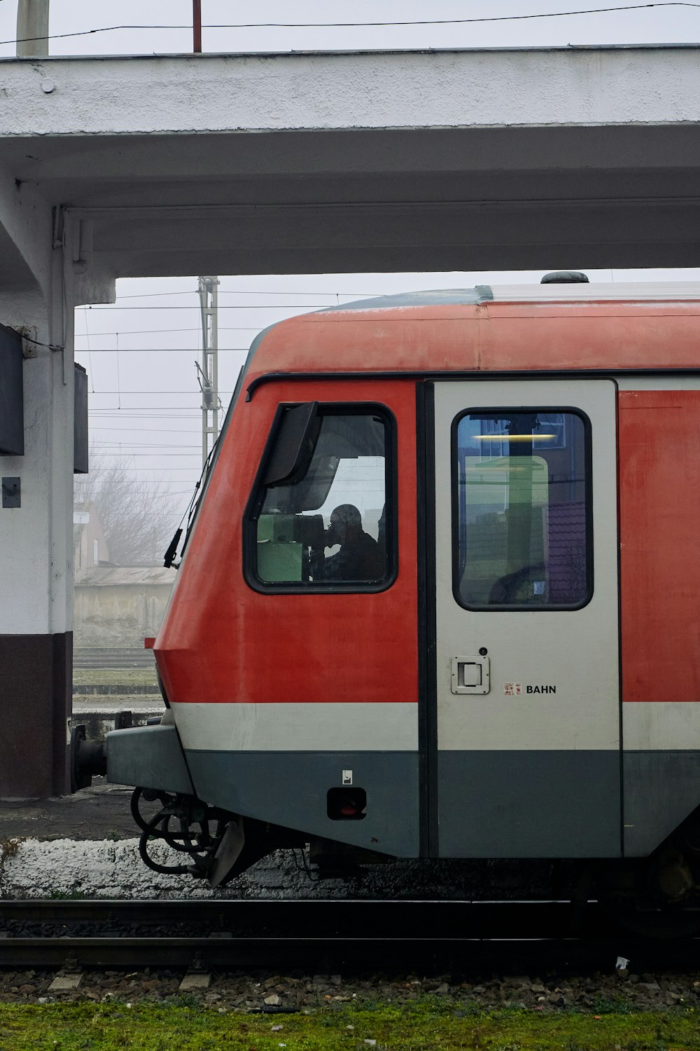 a red and white train sitting at a train station