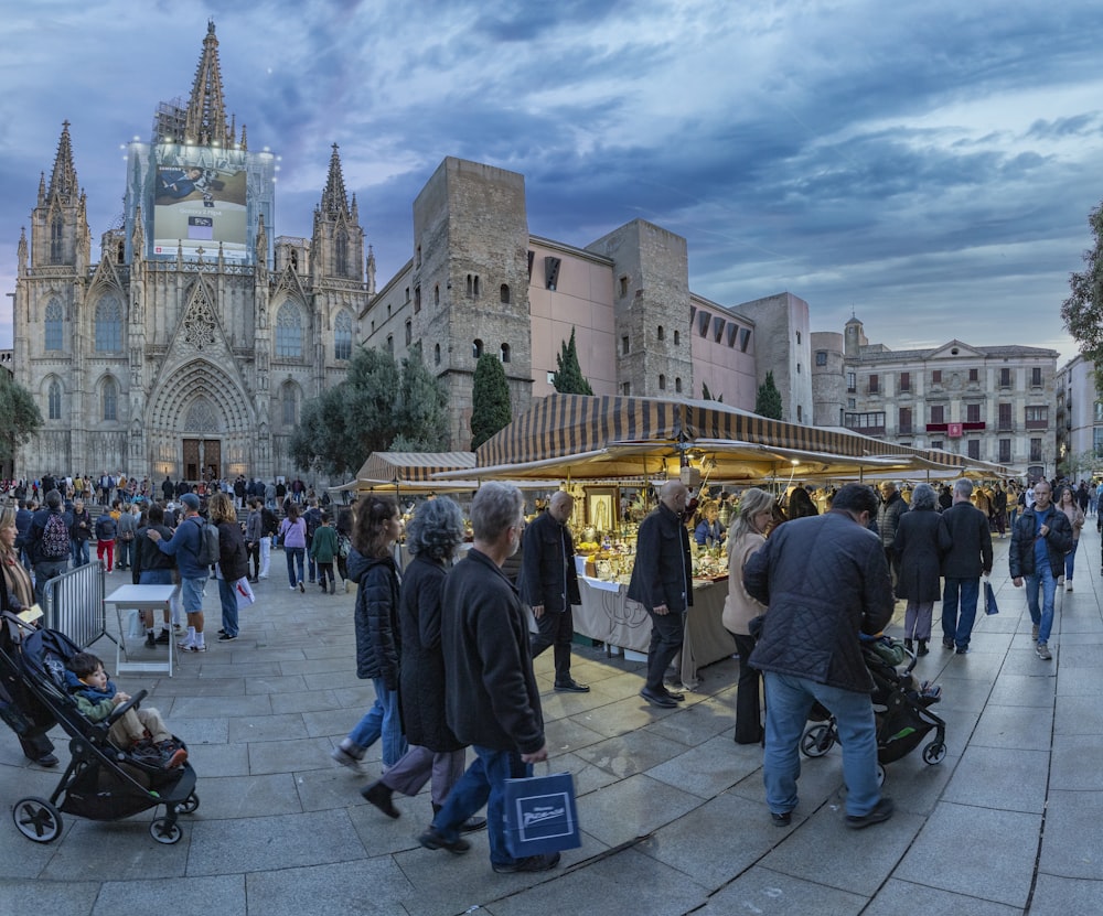 a crowd of people walking around a market