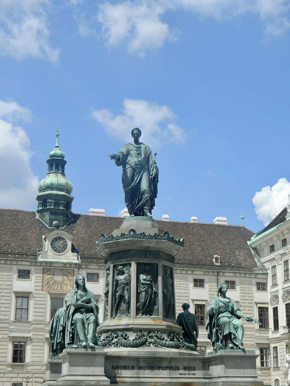 a statue in front of a building with a sky background