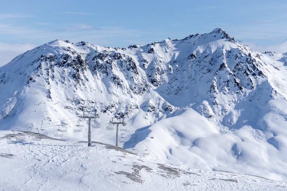 Una montaña cubierta de nieve con un remonte en primer plano