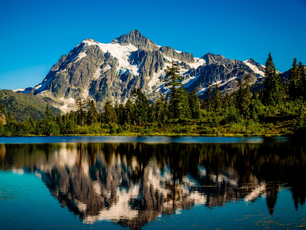 a mountain is reflected in the still water of a lake