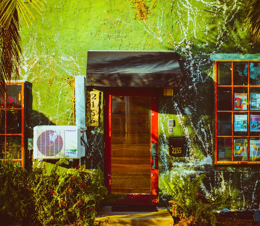 a green building with red doors and windows