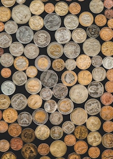 a bunch of different types of coins on a black background