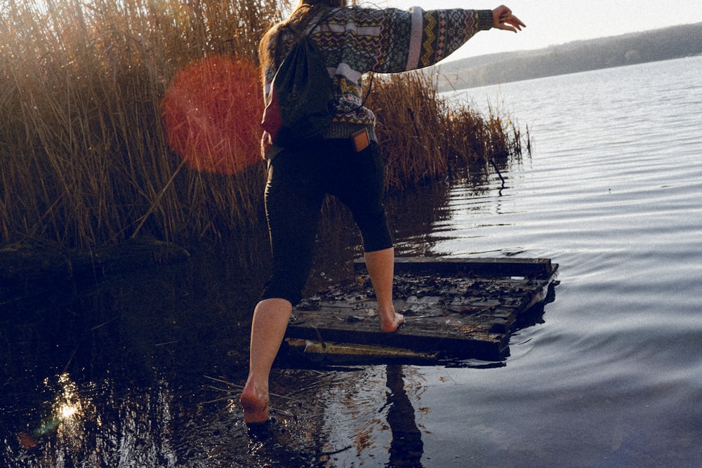 a woman standing on a dock in the water