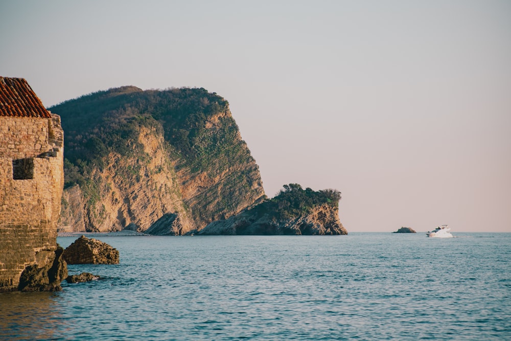 a boat is in the water near a mountain