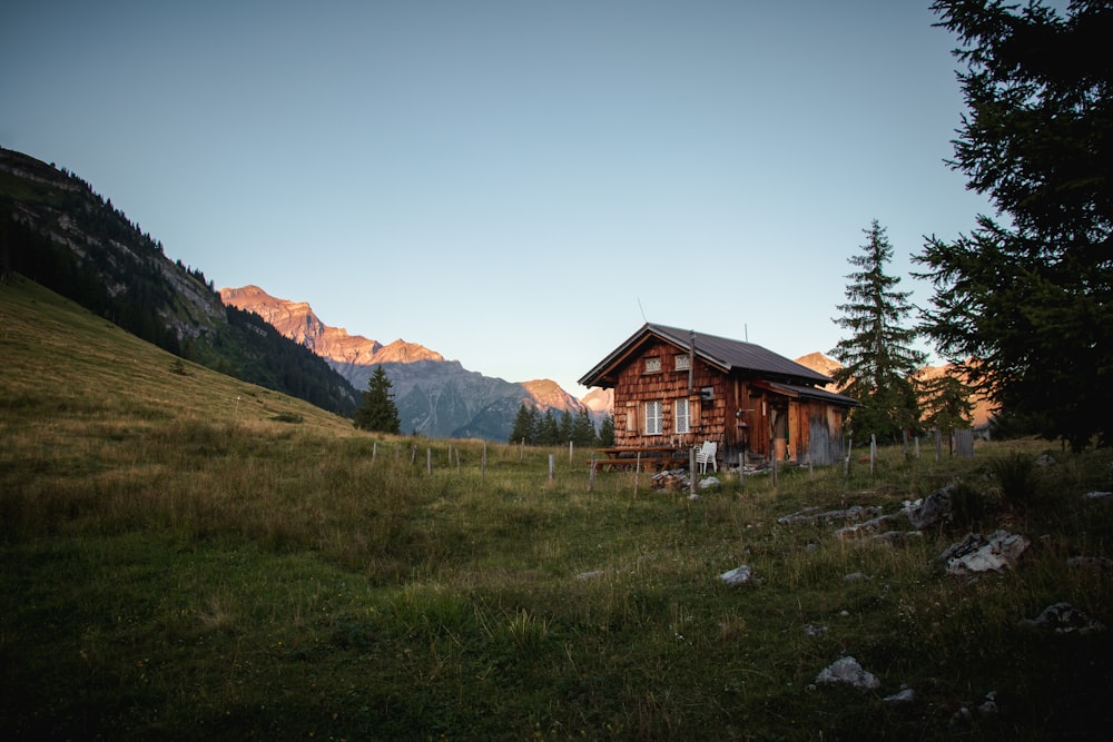 a small cabin in the middle of a grassy field