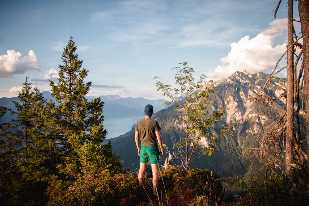 a man standing on top of a lush green hillside