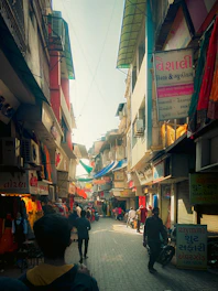 A vibrant street scene in Lucknow showing colorful markets and historical architecture under a bright sky.