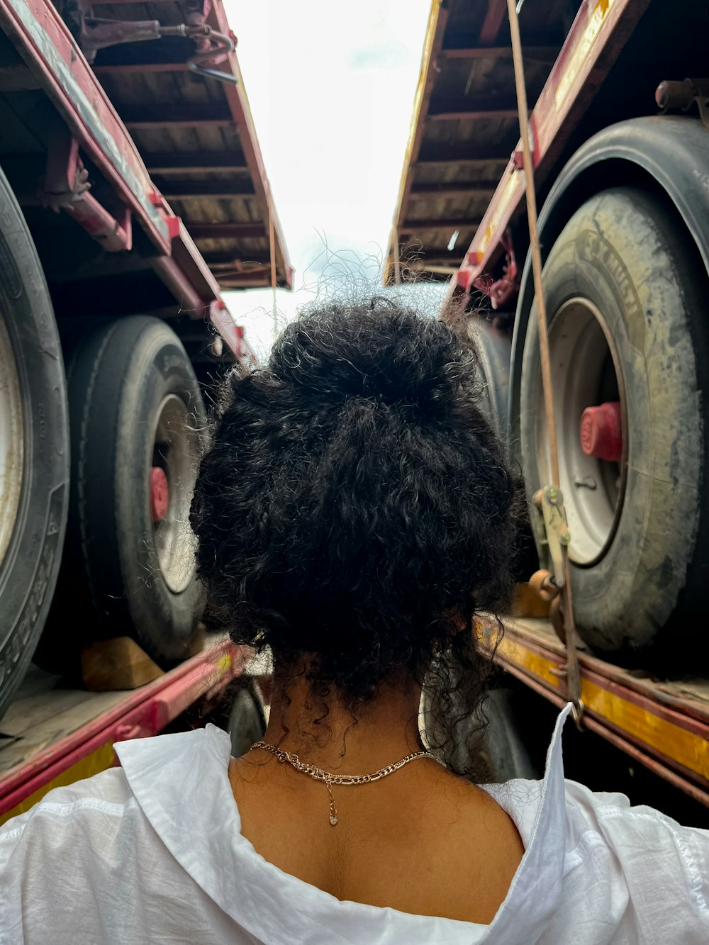 the back of a woman's head as she sits in front of a truck