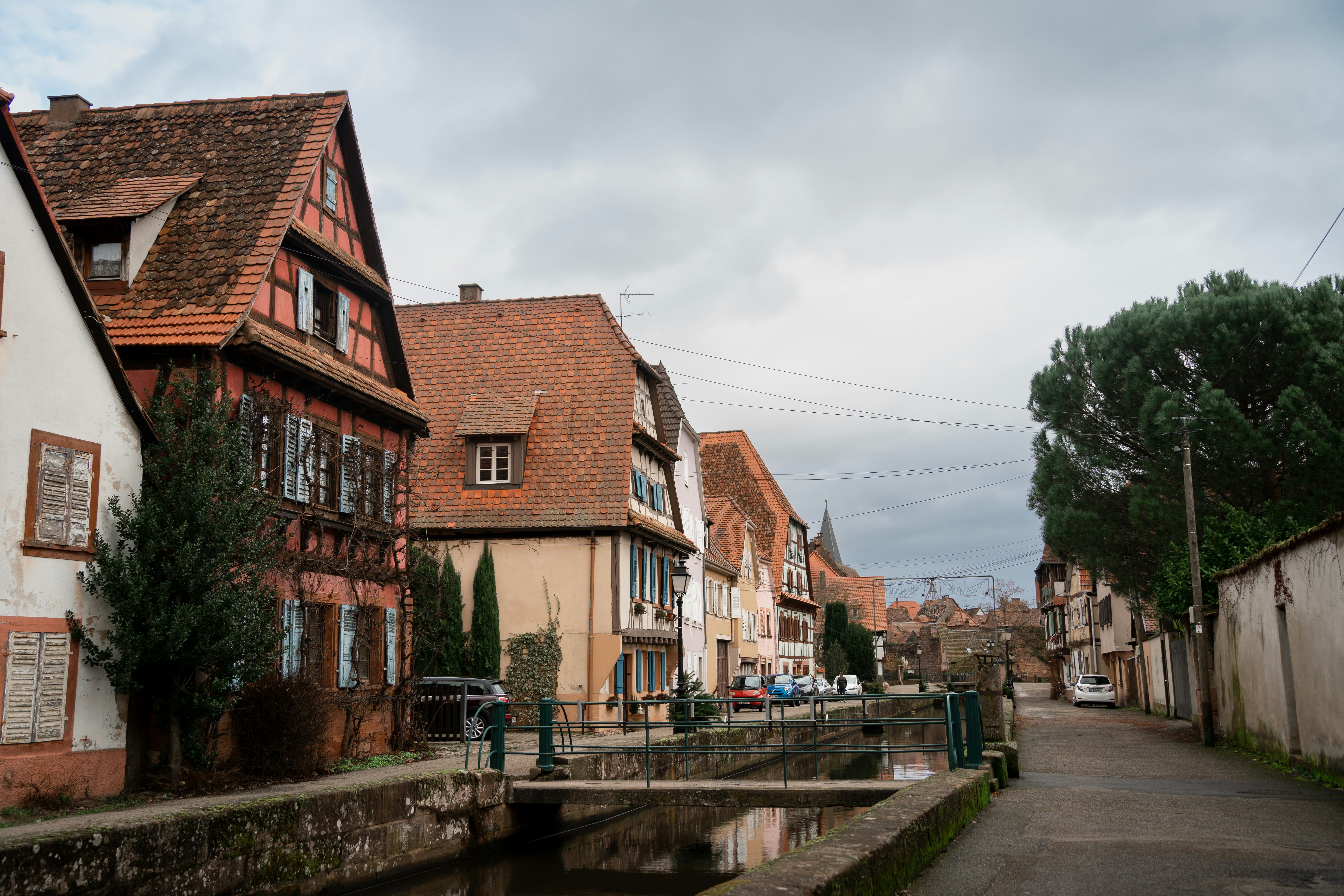 a street with buildings and a bridge in the middle of it, 