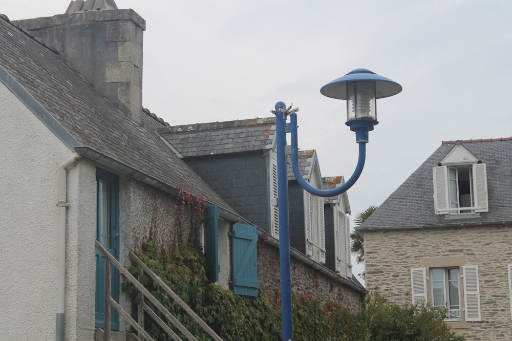 a street light next to a building with ivy growing on it