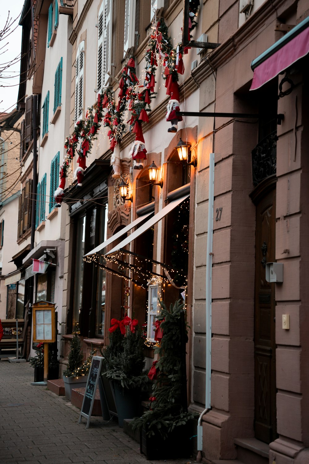 a row of buildings with christmas decorations on the windows