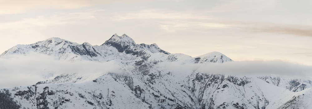 a mountain covered in snow with a few clouds