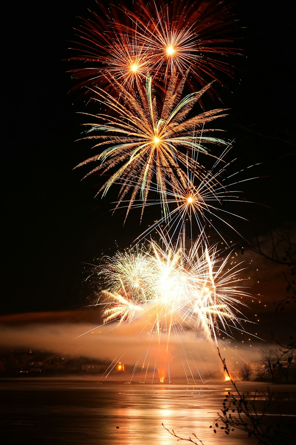 a firework display over a body of water at night