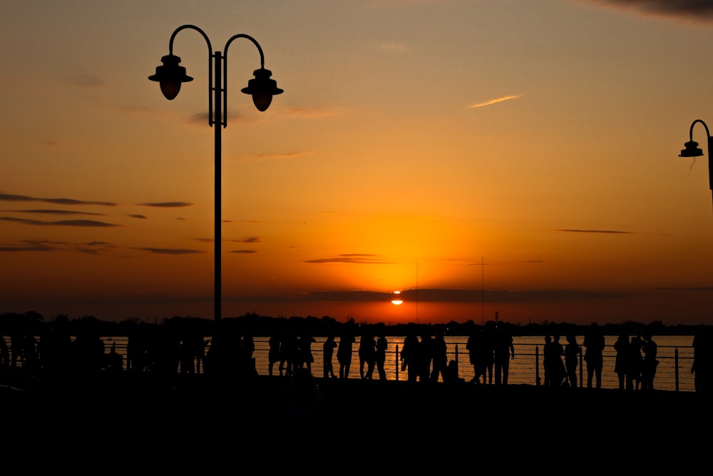 a group of people standing on top of a pier