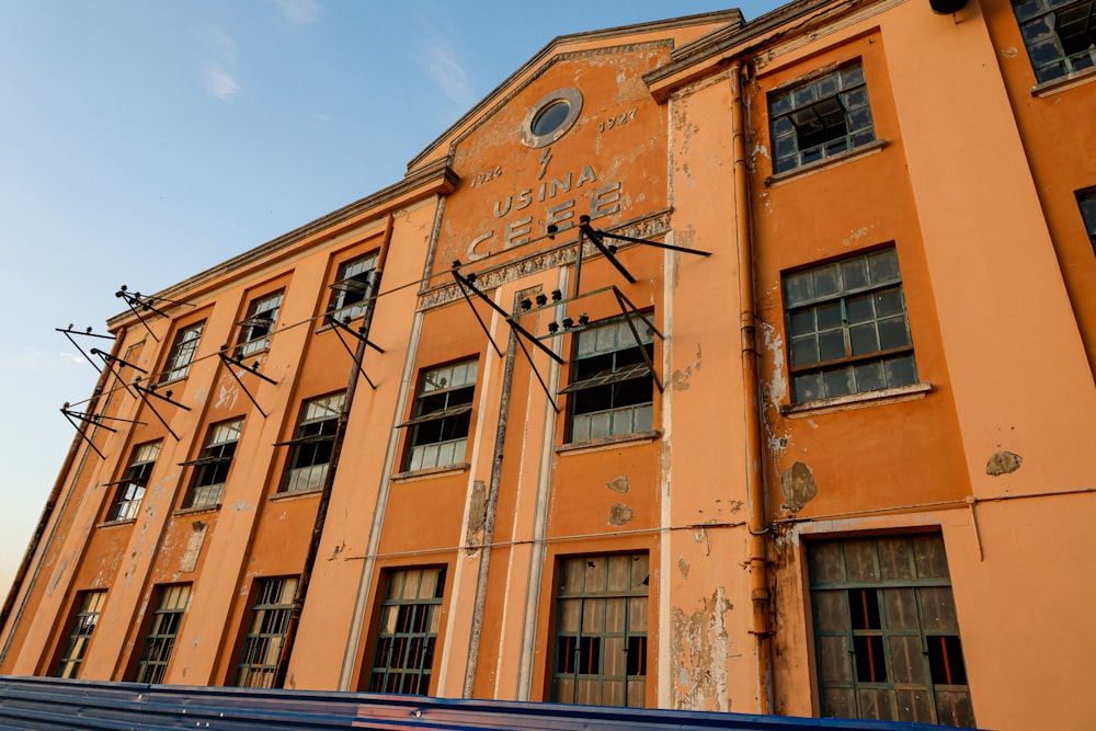 Un edificio naranja con un reloj en el costado