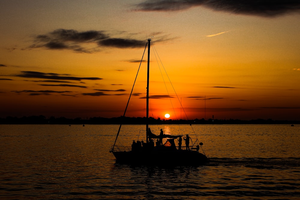 a sailboat in a body of water at sunset