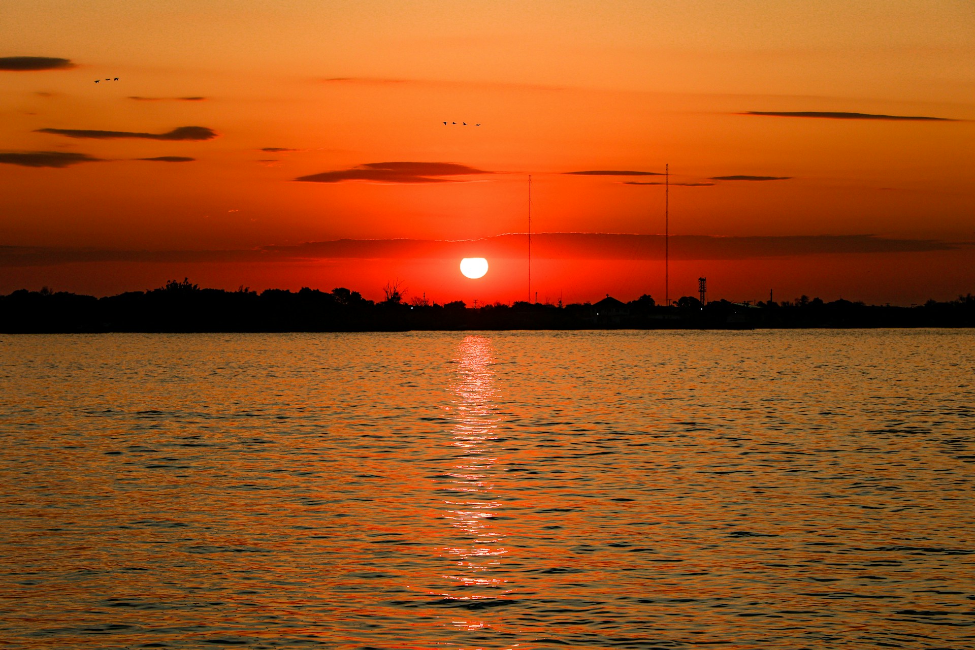 a large body of water with a sunset in the background