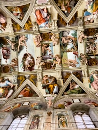 the ceiling of a building with many paintings on it