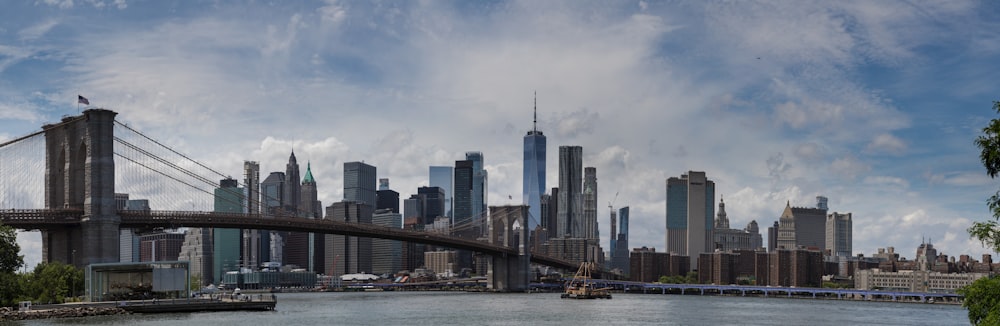 a bridge over a body of water with a city in the background