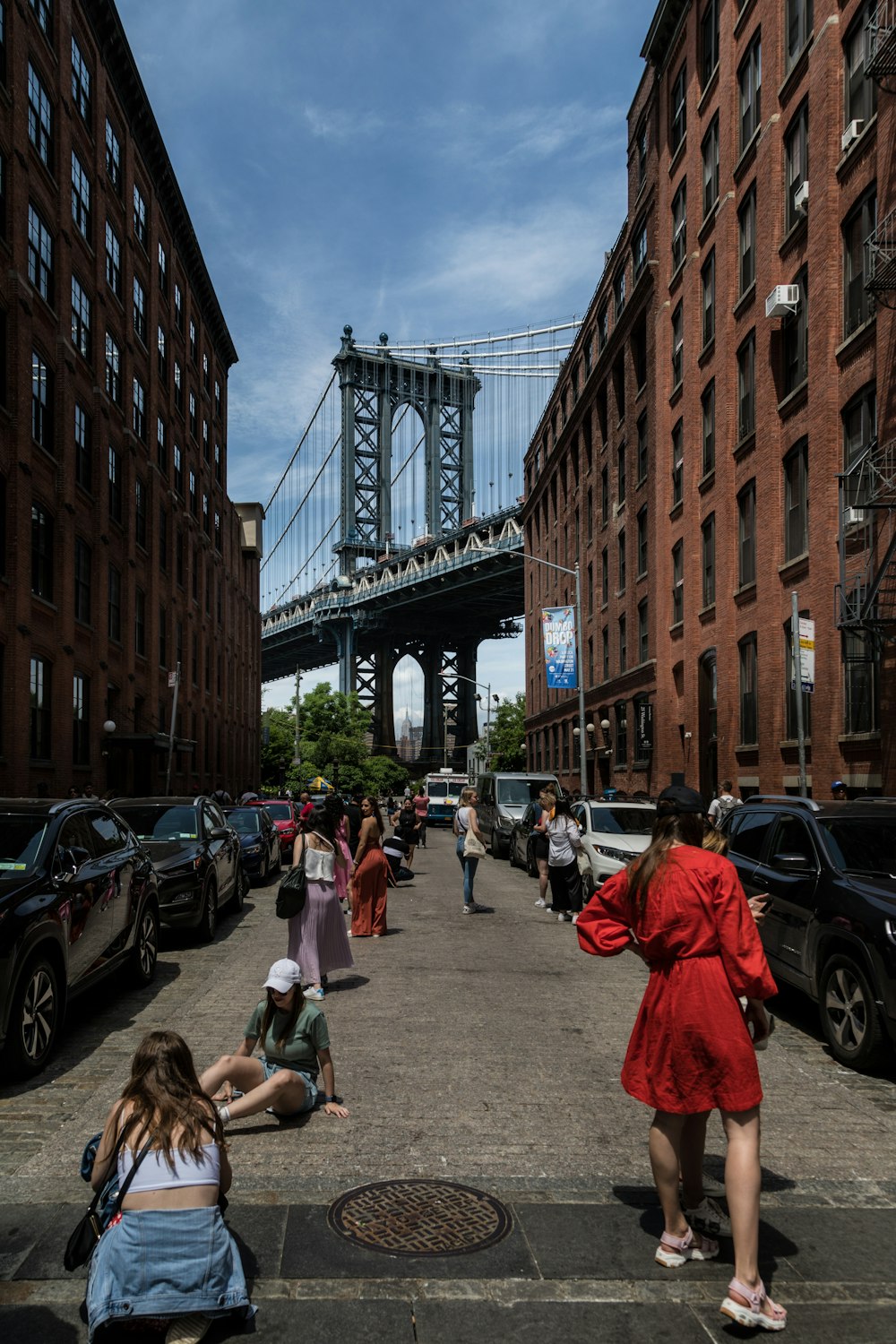 a group of people walking down a street next to tall buildings