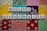 Scrabble tiles spell out 'neuro diversity' against a vibrant, ornate background composed of colorful square tiles with floral and geometric patterns.