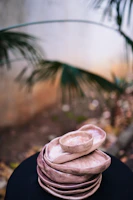 A set of colorful stoneware plates stacked neatly beside a window with soft natural light.