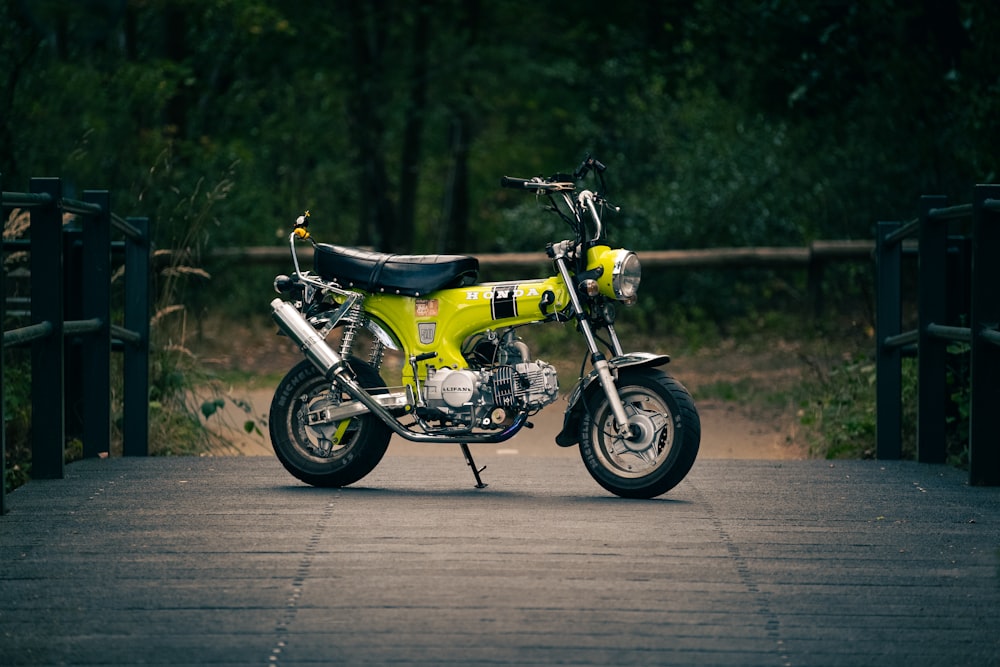 a yellow and black motorcycle parked on a bridge