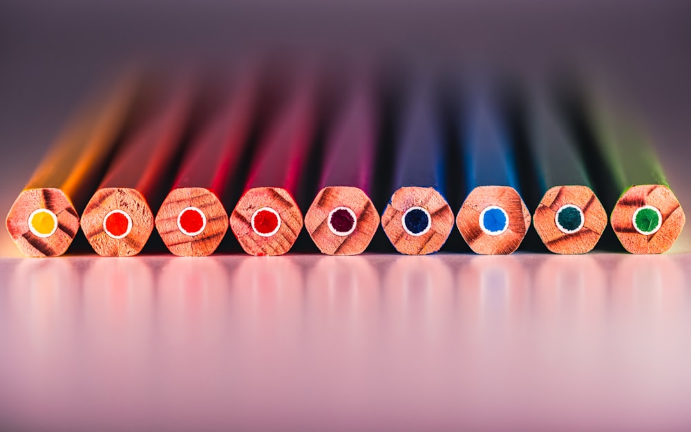 a row of colored pencils sitting on top of a table