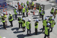 a group of construction workers standing around each other