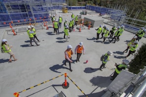 Woman in safety vest discussing plans with colleagues on a construction site.