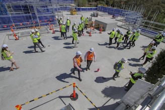 Woman in safety vest discussing plans with colleagues on a construction site.