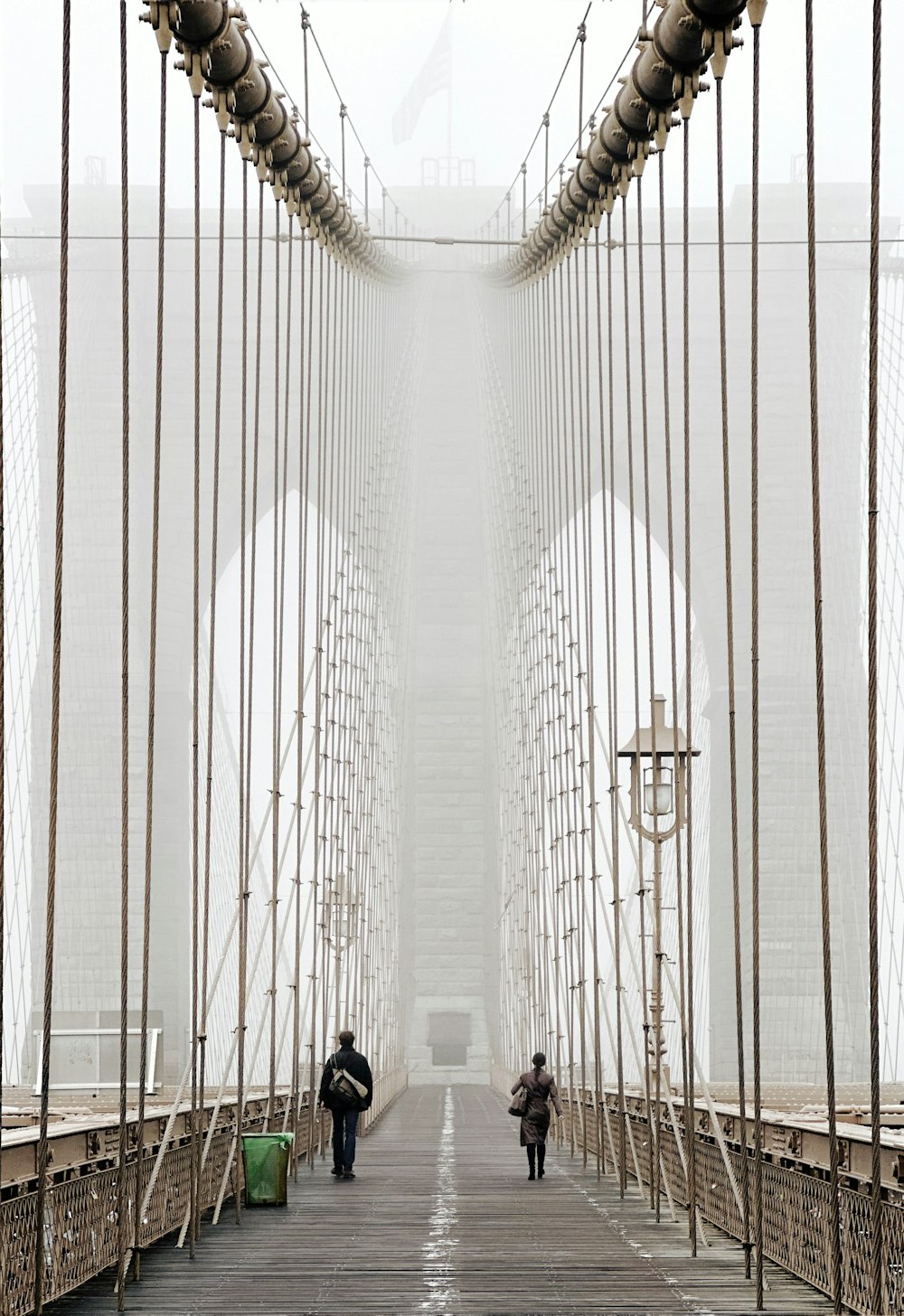 a couple of people walking across a bridge