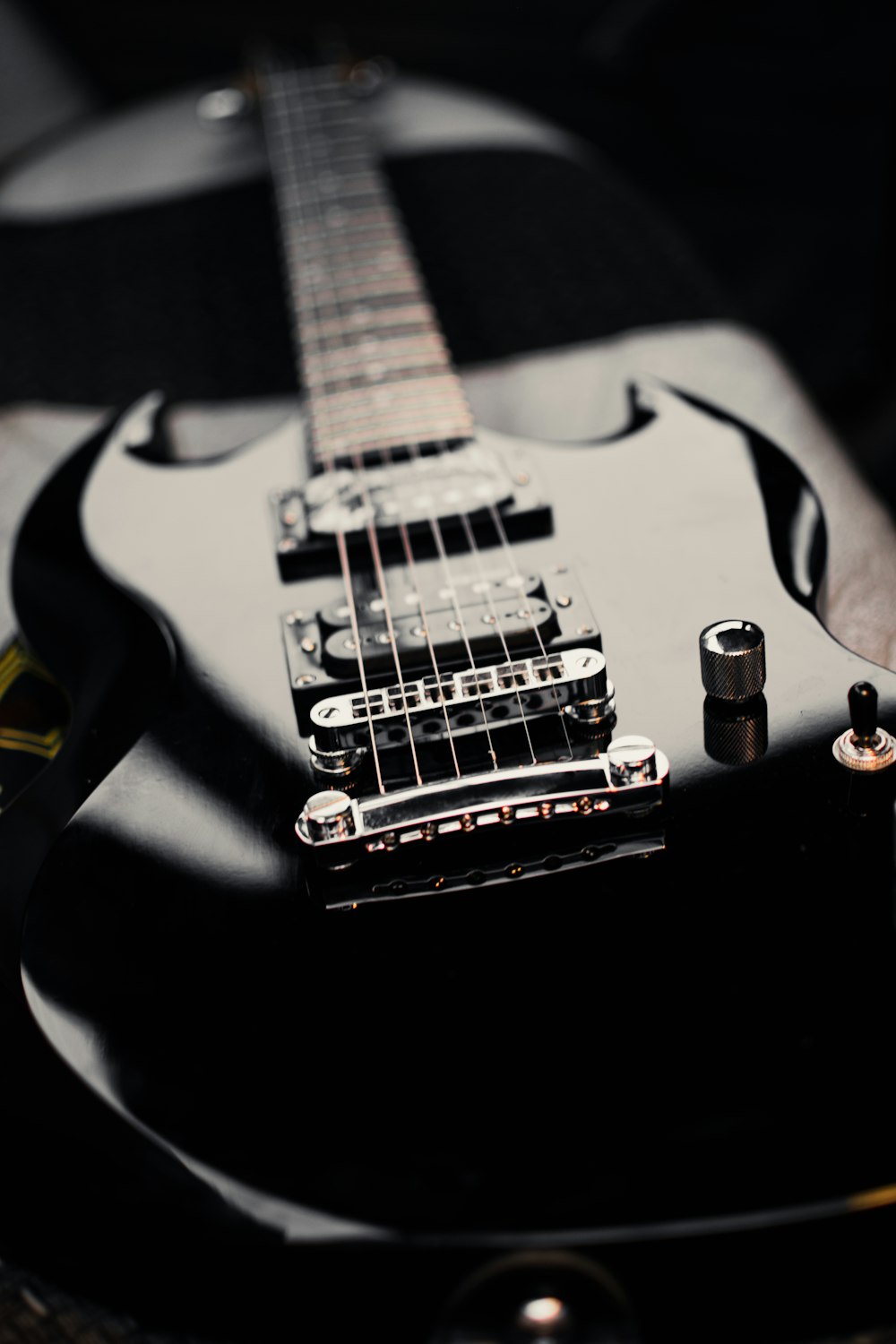 a black electric guitar sitting on top of a table