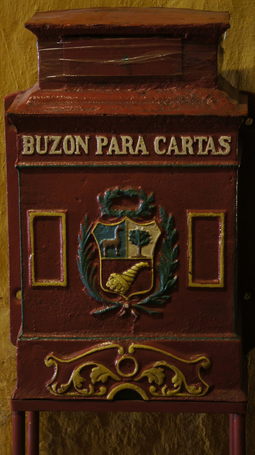 a red mailbox with a coat of arms on it