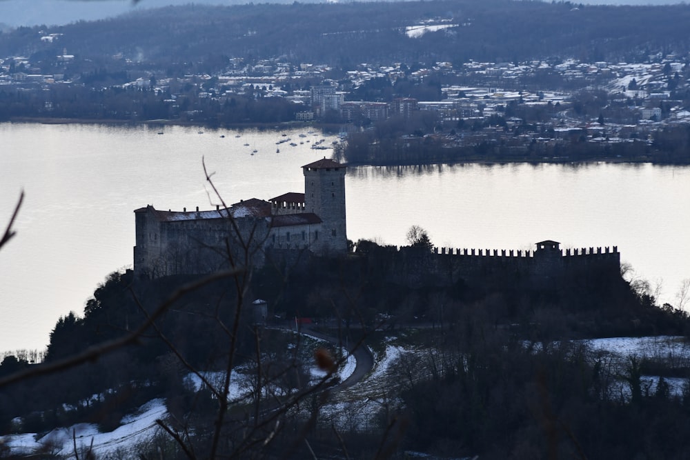 a castle on top of a hill with a lake in the background